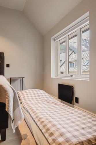 a bedroom with a bed and a flat screen tv at Odda Central Apartment in Odda