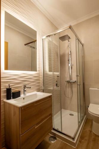 a bathroom with a shower and a sink and a toilet at RMR Tavira Charm & Comfort in Tavira
