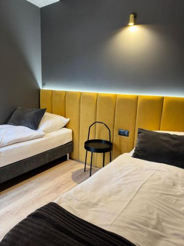 a room with two beds and a chair in it at Klimatyczne pokoje na Ligonia in Turza Śląska