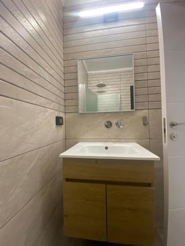 un baño con lavabo y espejo en Relaxation Hub Ashdod Studio Escape, en Ashdod