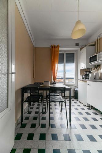 une cuisine avec une table et des chaises dans une pièce dans l'établissement Le Victoria - Appartement cœur de ville avec vue, à Vichy