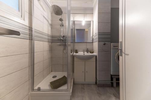 une salle de bain avec une douche, une baignoire et un lavabo dans l'établissement Le Victoria - Appartement cœur de ville avec vue, à Vichy