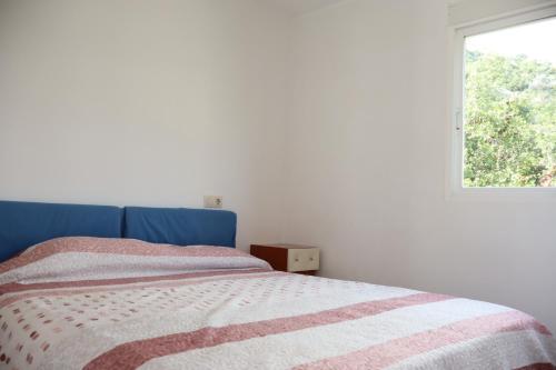 a bedroom with a bed with a blue headboard and a window at Montemar LEK in Peñíscola