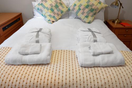 a pile of towels sitting on top of a bed at Spacious Apartment, Near Birmingham Centre + NEC in Birmingham