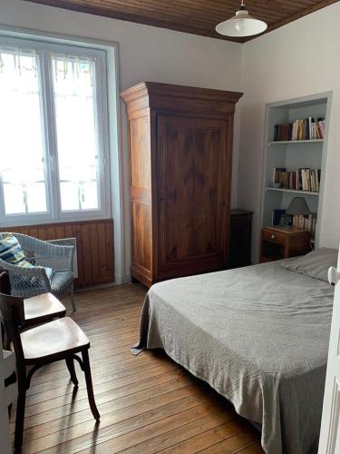 - une chambre avec un lit, une chaise et une étagère dans l'établissement Villa l'Aurore - Maison de vacances tout confort face à la plage des 5 Pineaux, à Saint-Hilaire-de-Riez