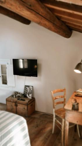 a living room with a table and a tv on the wall at Il Glicine - Natural BnB in Castello di Godego