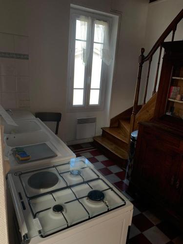 - une cuisine avec une cuisinière dans l'établissement Villa l'Aurore - Maison de vacances tout confort face à la plage des 5 Pineaux, à Saint-Hilaire-de-Riez