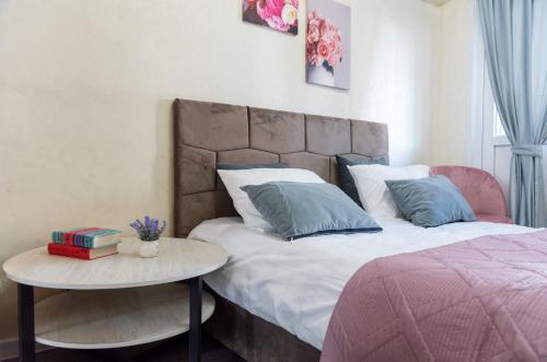 1 dormitorio con 1 cama y 1 mesa con libros en On Arbat the Center of Almaty, en Almaty