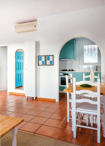 a kitchen and dining room with a table and chairs at Los Bungalows Del Arenal in Jávea