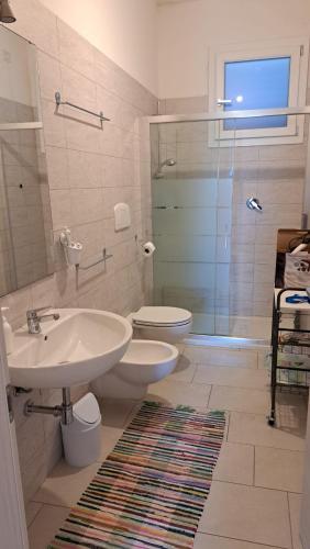 a bathroom with a sink and a toilet and a shower at Anninnìa Guest House B&B - GhiIarza in Ghilarza