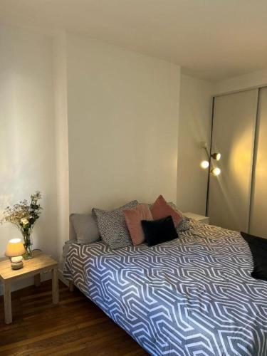 une chambre avec un lit avec une couette bleue et blanche dans l'établissement Cosy Haven Paris 14, à Paris
