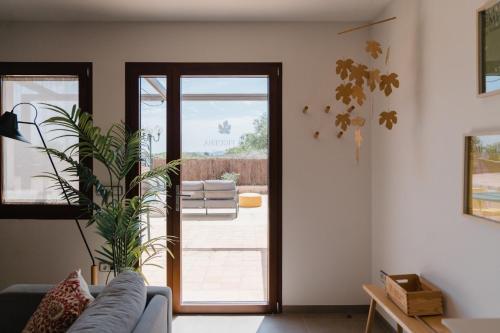 a living room with a couch and a sliding glass door at La Figuera in Ultramort