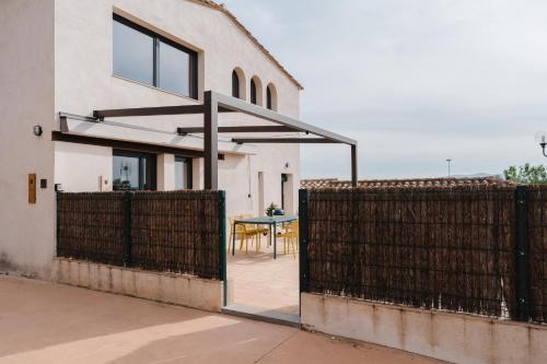 an open gate to a house with a table behind it at La Figuera in Ultramort
