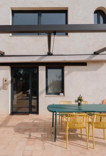 a patio with a green table and chairs at La Figuera in Ultramort