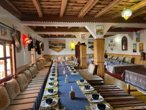 a long dining room with long tables and chairs at Maison D'hôte La Vallée Des Figues in Tamellalt