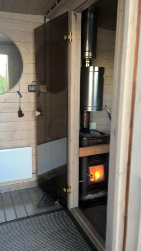 a kitchen with an oven with a fire in it at Yli-Kaitala Hut in Mankala