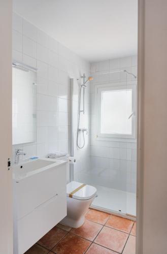 a bathroom with a toilet and a tub and a sink at Los Bungalows Del Arenal in Jávea