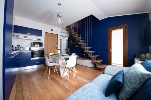 un soggiorno con pareti blu e una cucina con scala di La Casa di Oliviero a Vetralla