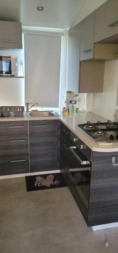 Il comprend une cuisine équipée d'une cuisinière. four supérieur à côté d'un évier dans l'établissement Bungalow spacieux avec piscine à Lattes, à Lattes