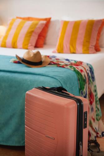 a pink suitcase sitting on the floor next to two beds at Los Bungalows Del Arenal in Jávea