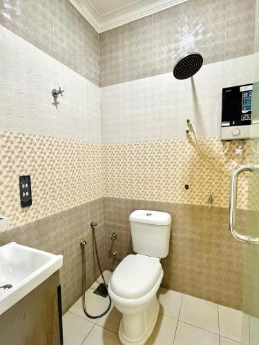 a bathroom with a toilet and a sink at Suza Hostel in Tumpat
