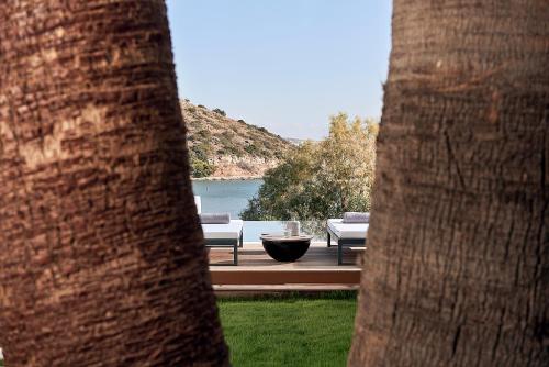 a view of a patio with chairs and a lake at The Sand Villa in Agios Nikolaos