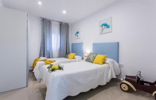 a bedroom with two beds with yellow pillows at El Balneario in Cádiz