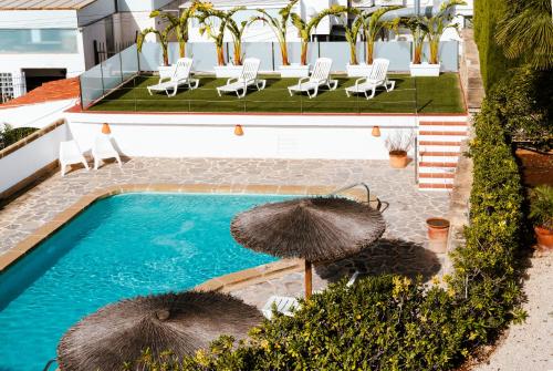 an overhead view of a pool with umbrellas at Los Bungalows Del Arenal in Jávea