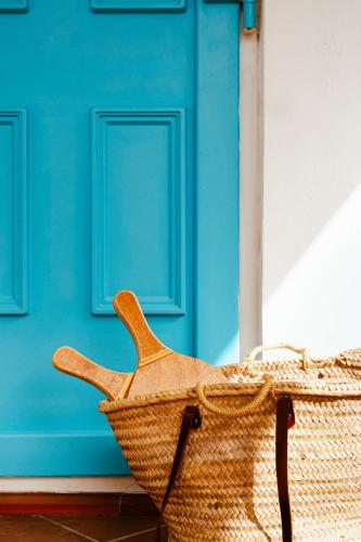 a wicker basket sitting in front of a blue door at Los Bungalows Del Arenal in Jávea