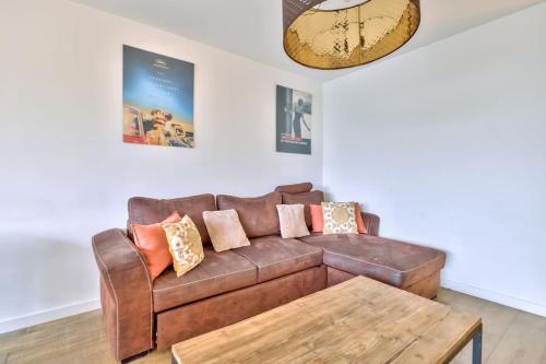 - un salon avec un canapé en cuir brun et une table basse dans l'établissement Lovely 2BR Flat with terrace and parking near the beach, à Cannes