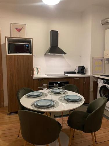- une cuisine avec une table, 4 chaises et une cuisinière dans l'établissement Magnifique & Cozy appartement au cœur de Strasbourg avec terrasse, à Strasbourg