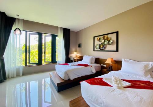 a hotel room with two beds and a window at Bangnu Greenery Resort in Takua Thung