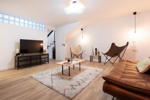 a living room with a couch and a tv at L'Atelier - Warm Porto Loft in Porto