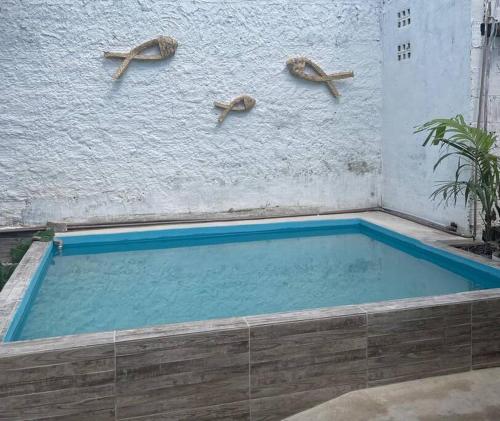 a swimming pool with three sharks on a wall at Aconchego em Gravatá in Gravatá
