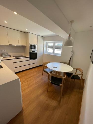 a kitchen and dining room with a table and chairs at Casa do Ferreiro T2 in Montalegre
