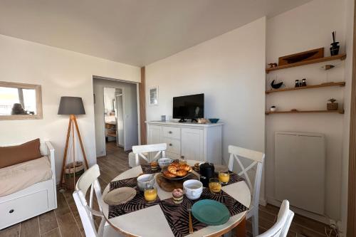 - une salle à manger avec une table et des chaises dans l'établissement Côté Mer - Appartement vue mer en première ligne, au Grau-du-Roi