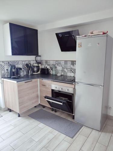 Il comprend une cuisine équipée d'un réfrigérateur blanc et d'une cuisinière. dans l'établissement Gite charme en pierre à la campagne, à Chouzé-sur-Loire