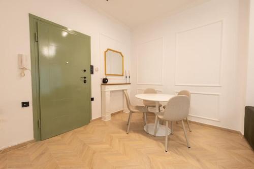 a dining room with a table and chairs and a green door at Iris Luxury Apartment in Serres