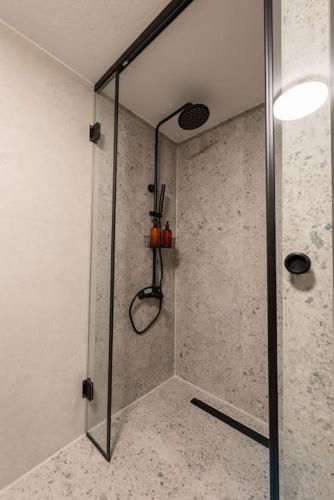a shower with a glass door in a bathroom at Iris Luxury Apartment in Serres