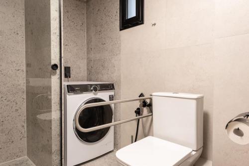 a bathroom with a washing machine and a toilet at Iris Luxury Apartment in Serres