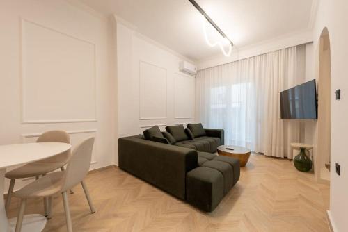a living room with a black couch and a table at Iris Luxury Apartment in Serres