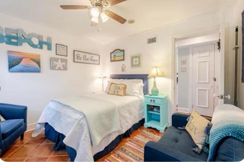 a bedroom with a bed and a blue chair at Pearls Pad - Beautiful 1 bedroom apartment- 1 block to beach in Tybee Island