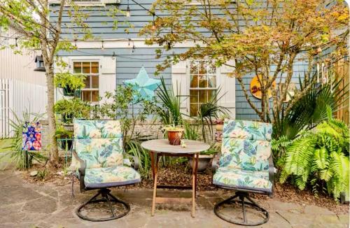two chairs and a table in a garden at Pearls Pad - Beautiful 1 bedroom apartment- 1 block to beach in Tybee Island