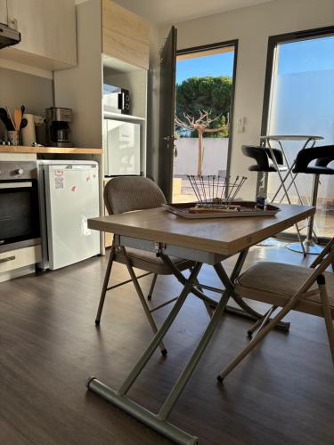 a kitchen with a table and chairs in a room at Charmant studio pour étudiant seul ou à 2 in Villeneuve-lès-Maguelonne