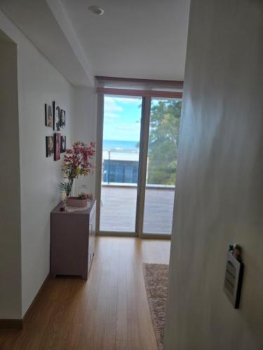 a living room with a large window and a table with flowers at The Stay Christmas in Jeju