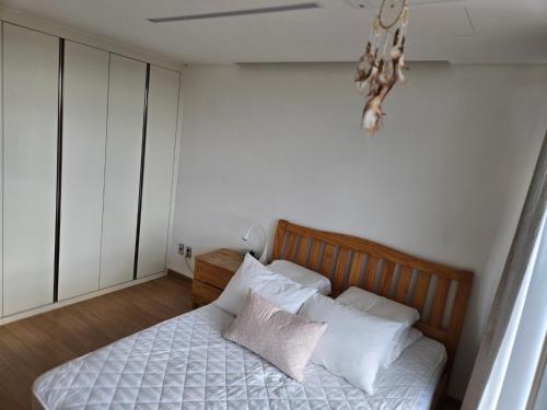 a bedroom with a bed with white sheets and pillows at The Stay Christmas in Jeju