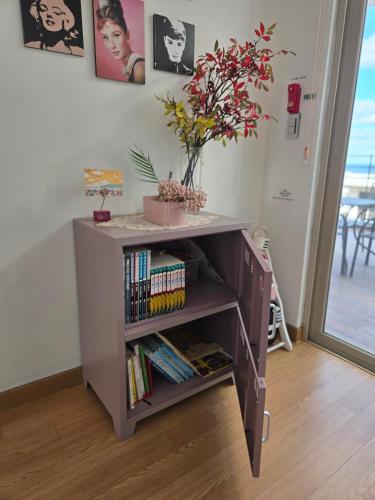 a book shelf with books and a vase of flowers at The Stay Christmas in Jeju