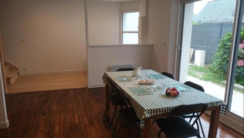 une salle à manger avec une table et des chaises et une fenêtre dans l'établissement Maison Spacieuse avec Terrasse extérieure, à Gouesnach