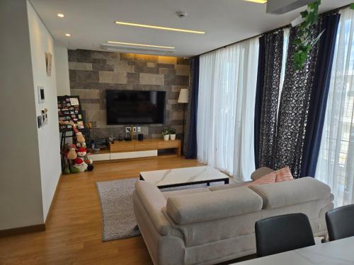 a living room with a couch and a flat screen tv at The Stay Christmas in Jeju