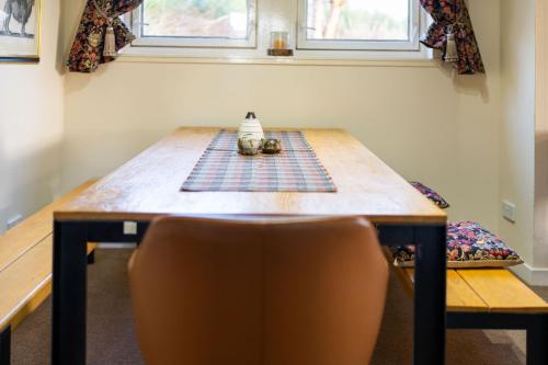 a table in a room with a chair and a table sidx sidx sidx at Milton of Tullypowrie Cottage in Pitlochry